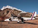 Annapurna 15 01 Boarding Plane In Hongde With Annapurna III Behind I made it. The Royal Nepal Airlines plane sits on the tarmac, eh, gravel, of the Hungde airstrip, with Annapurna III glistening in the morning sun. I gave the boys their tips, and the flight took off 8:50.